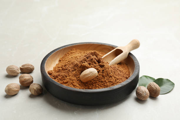 istock Bowl of nutmeg powder with seeds on white table 1434447212