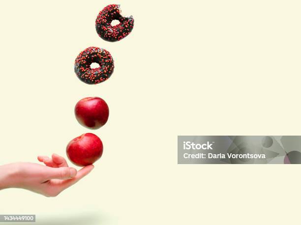 Flying Levitating Floating Red Ripe Fresh Apples With Sweet Glazed Doughnutdonut In Air Above Womens Hand On Green Backgroundcreative Fruitsdesserttrendy Minimal Foodhealthy Unhealthy Nutrition Stock Photo - Download Image Now