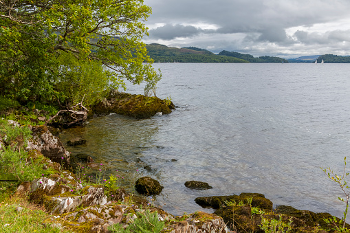 View across Loch Lomond taken from the rocky beach near Cashel, Scotland, UK.