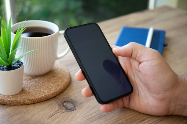 istock male hands hold phone with black screen background cafe 1434452833