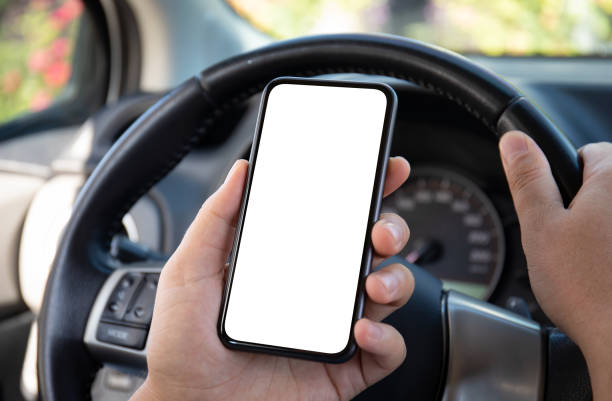 istock male hands hold phone with isolated screen background steering wheel 1434458252