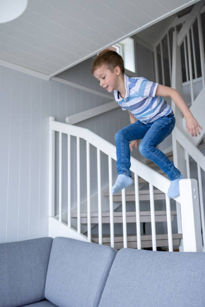 istock Boy jumping from stairscase in the house 1434461382