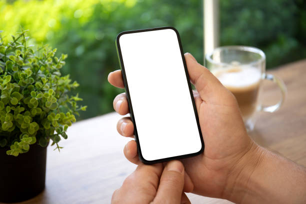 istock man hands holding phone with isolated screen in green cafe 1434462374