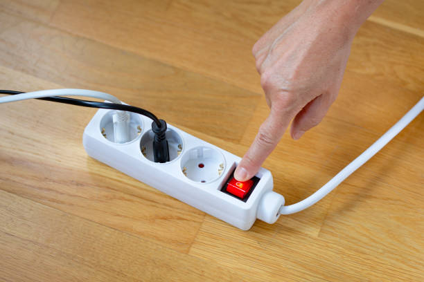 木製の背景にある白い電源タップの赤いボタンを押す - extension cord push button cable electric plug ストックフォトと画像