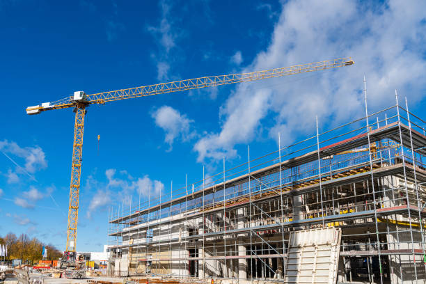 istock Yellow tower crane above a building under construction in scaffolding. 1434462785