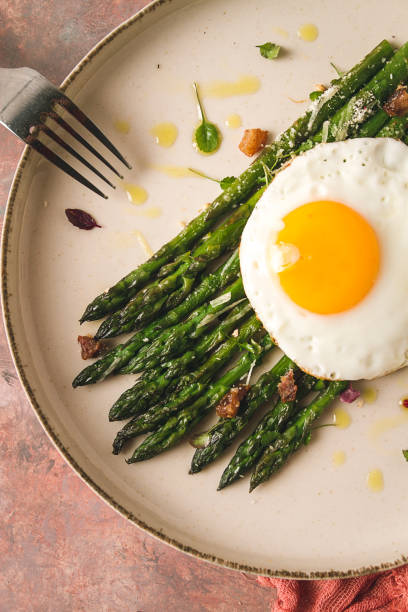 istock grilled asparagus, with fried egg, spices and herbs, parmesan cheese, on a beige plate, top view, rustic, no people 1434466480