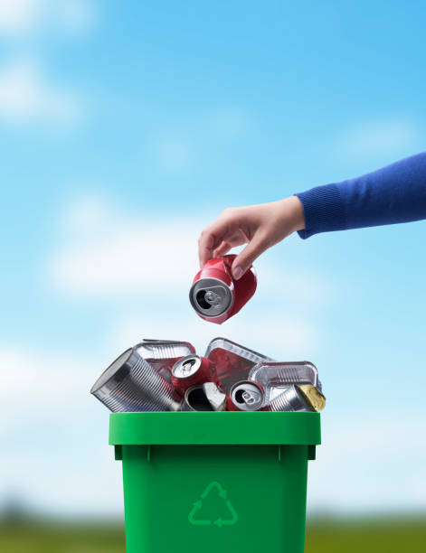 istock Woman throwing a can in the recycling bin 1434466539
