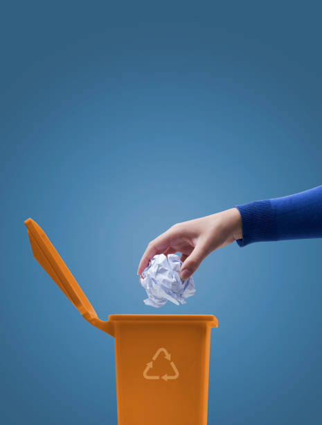 istock Woman putting paper in the trash bin 1434466691