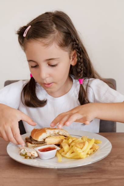 istock Little girl eating a big burger 1434467918