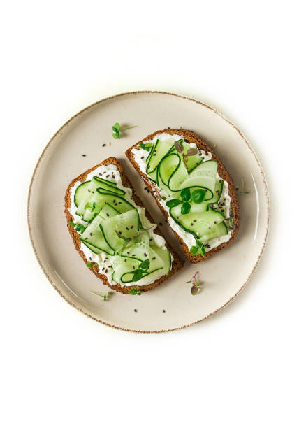 istock Breakfast, cereal bread sandwiches, cream cheese, sliced cucumber, with micro greenery on a light table, close-up, top view, selective focus, no people, 1434468038