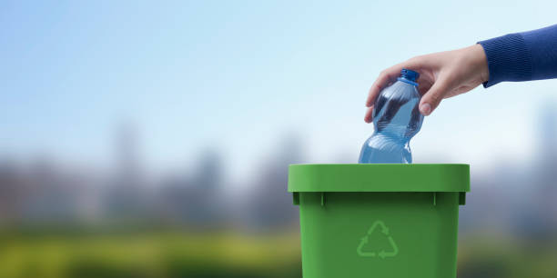 istock Woman putting a plastic bottle in a trash bin 1434468443