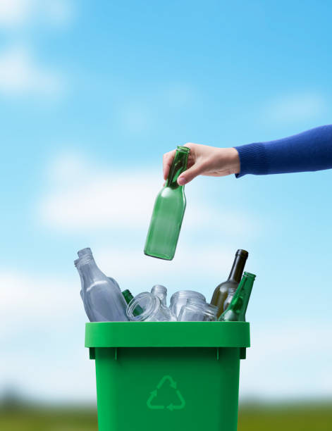istock Woman putting a glass bottle in the trash bin 1434468694