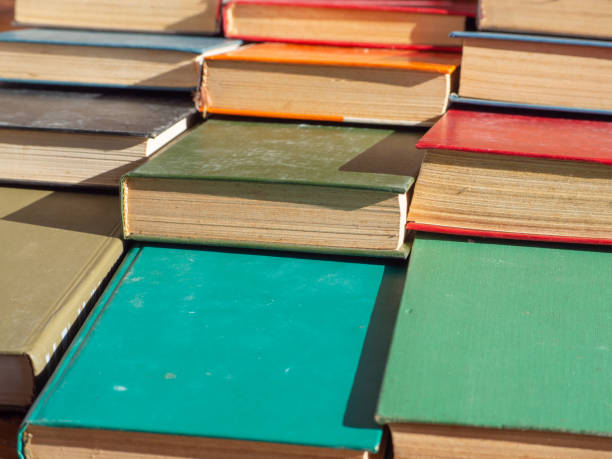istock Dusty old hardcover books stacked in rows on the table. Book background texture 1434468844