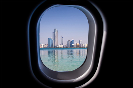 View from a jet plane window high on blue sky on Abu Dhabi UAE