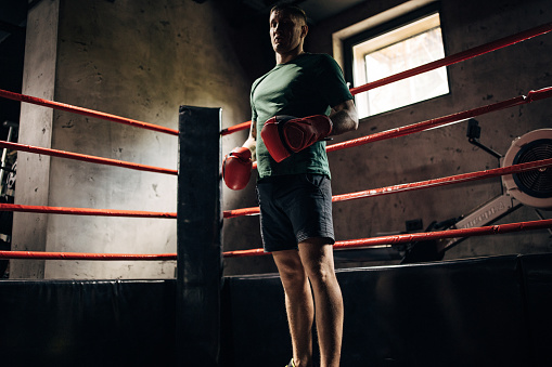 Caucasian male boxers practicing in a gym.Entering a ring for a sparring practice. Working hard in a boxing gym, sweating.