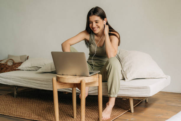 istock Young happy female student studying online using laptop and headphones. 1434473223