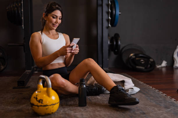 istock Woman using mobile phone in the gym 1434473962