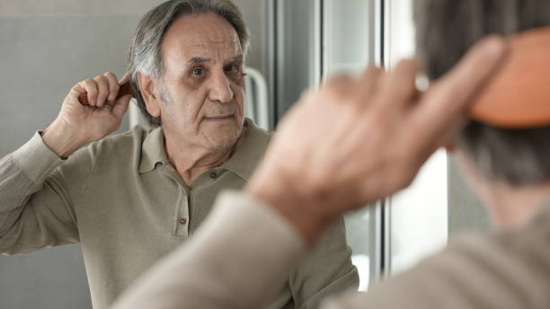 istock Senior man combing his hair in the bathroom 1434474157