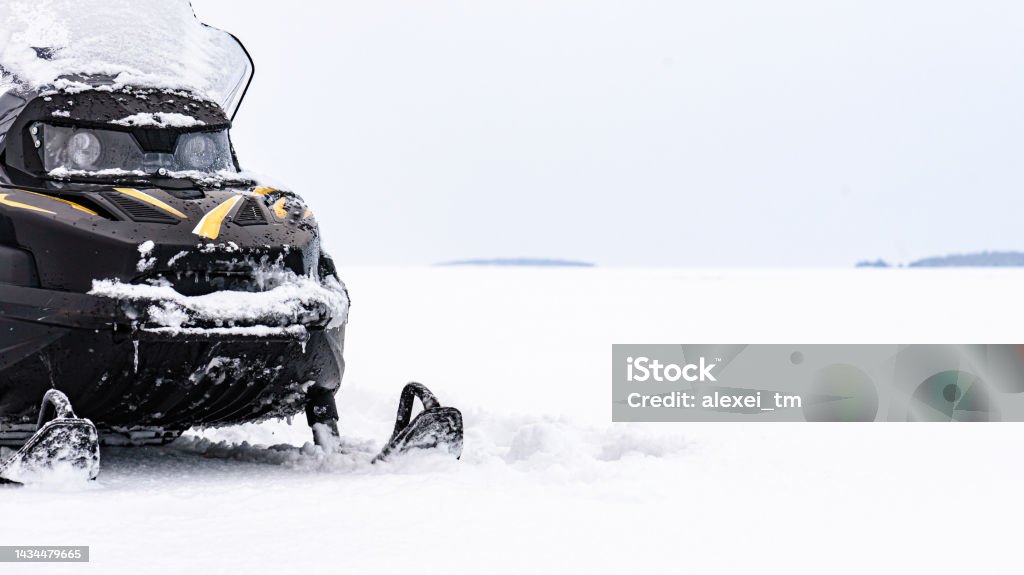 Panoramic background with snowmobile on ice of frozen lake on winter day Family tour in wild nature of Finland on snowmobiles Backgrounds Stock Photo