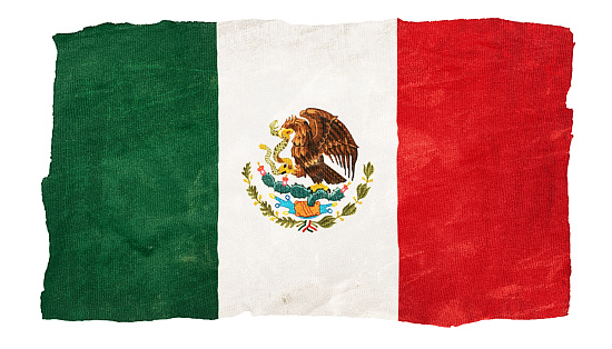 Horizontal view of a Mexican national flag waving in the wind against a clear blue sky.