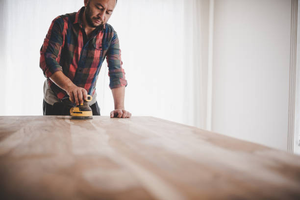 istock DYI man sanding a wood table inside his house 1434480748