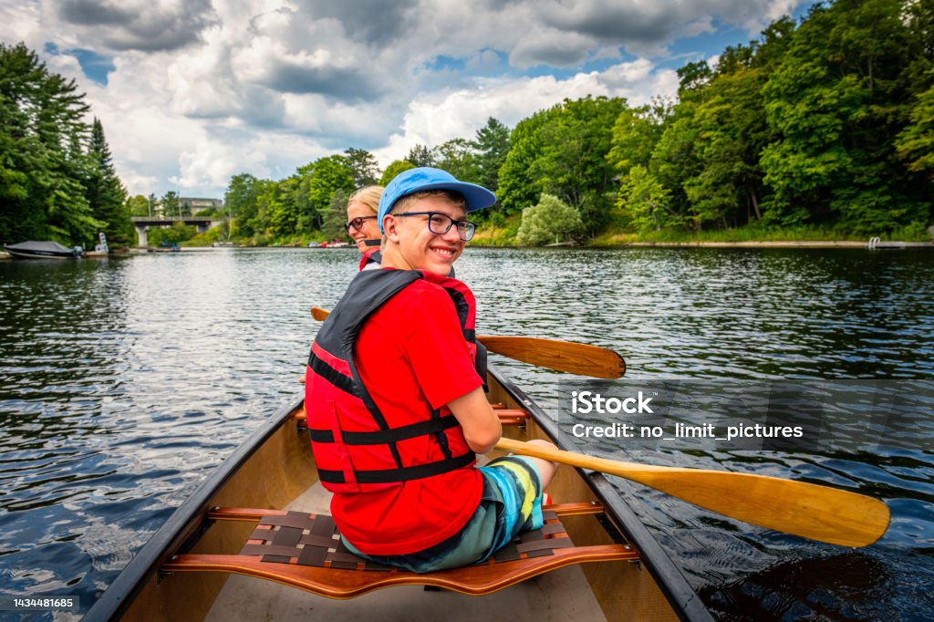 mother and her son are canoeing at Fairy Lake in Huntsville in Canada Mother and her son are canoeing at Fairy Lake in Huntsville in Canada. It is part of the Algonquin Provincial Park. Canoeing Stock Photo