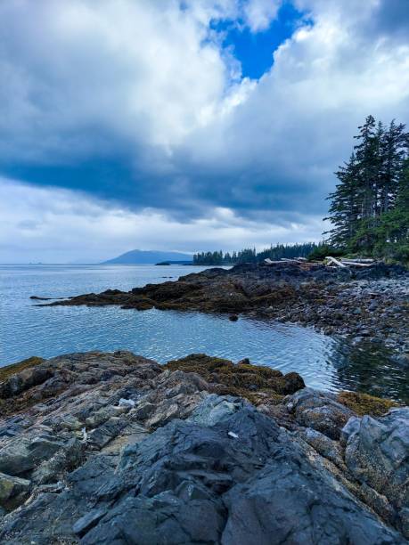 istock Rocky and sandy beach view with cloudy sky background 1434484372