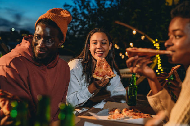 los amigos están cenando juntos con pizza - pizza party fotografías e imágenes de stock