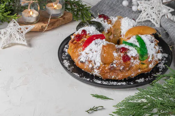 Bolo Rei or King's Cake is a traditional Xmas cake with fruits raisins nut and icing  on kitchen countertop. Is made for Christmas, Carnavale or Mardi Gras