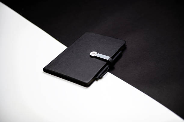 istock black organizer or notebook with pen on two-color black and white background, mockup, copy space 1434487687