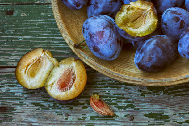 istock ripe plum in wooden plate, on old table 1434494005