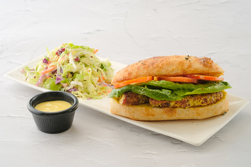 Honey Mustard Chicken Sandwich with salad and dip served in a dish isolated on background side view of fastfood