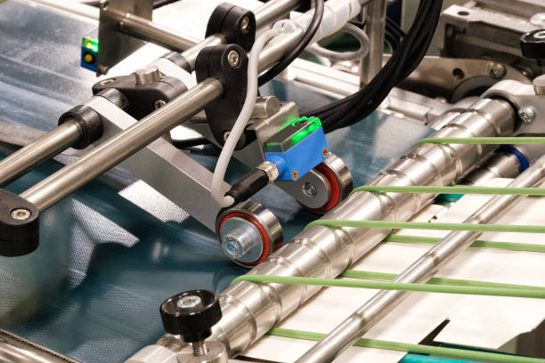 istock Elements of corton boxes are collected in stack. Conveyor line for the production of boxes. Machine cuts cardboard boxes from sheets of cardboard. Enterprise for the production package. 1434497683