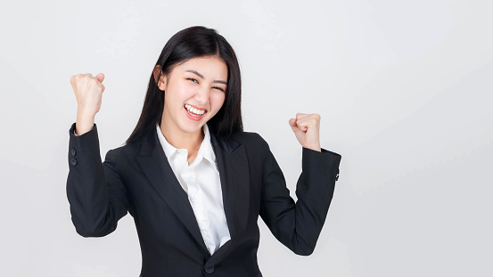 Portrait beautiful working Asian woman with happiness raise both arms celebrating success isolated on white background - business concept