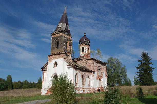 an old abandoned building of the Russian Orthodox Church on the edge of a Karelian village, on a sunny day against the blue sky