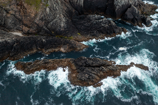 Lonely tourist on a hike along the cliffs of Eshaness, cold autumn day, Shetland Islands.