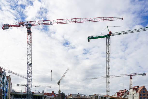 istock Several construction tower cranes at city construction sites against a cloudy sky background 1434502270