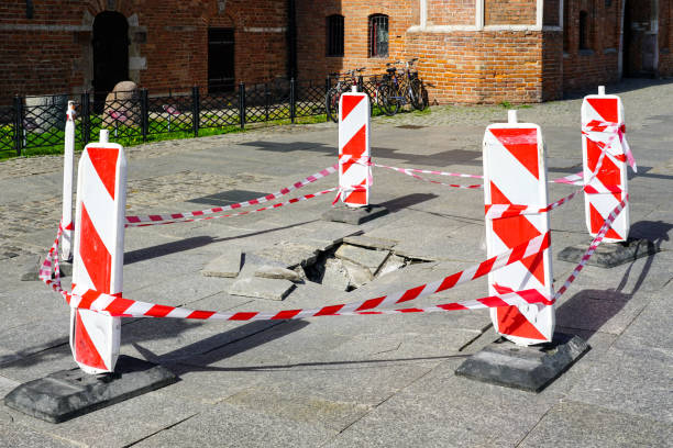 istock Broken cobblestone pavement slabs due to incorrectly prepared base, restricted by warning signs 1434502328