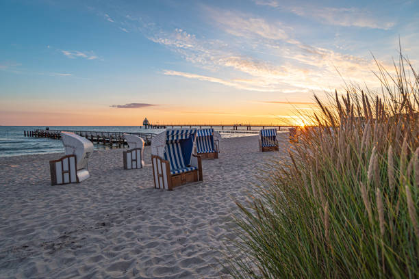 Fischland Darß Zingst - Strand in Zingst bei Sonnenaufgang Blick auf den Strand und die Seebrücke von Zingst bei Sonnenaufgang hooded beach chair stock pictures, royalty-free photos & images