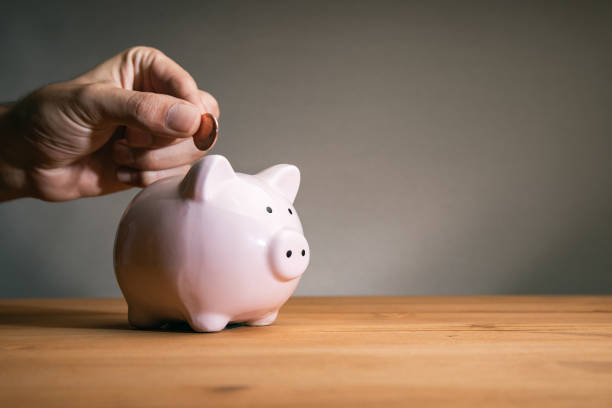istock Puts a coin in a piggy bank 1434505345