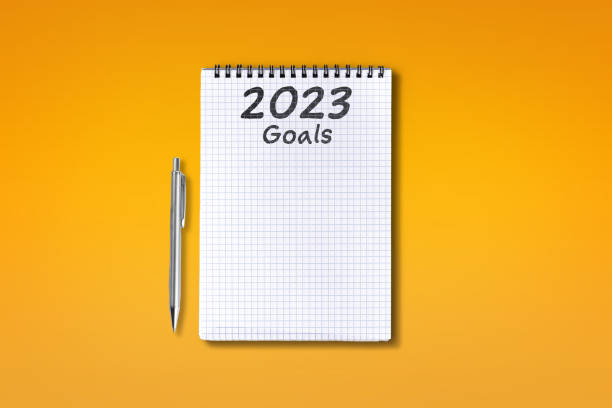 2023 Goals lettering on checkered notebook, isolated on orange background stock photo