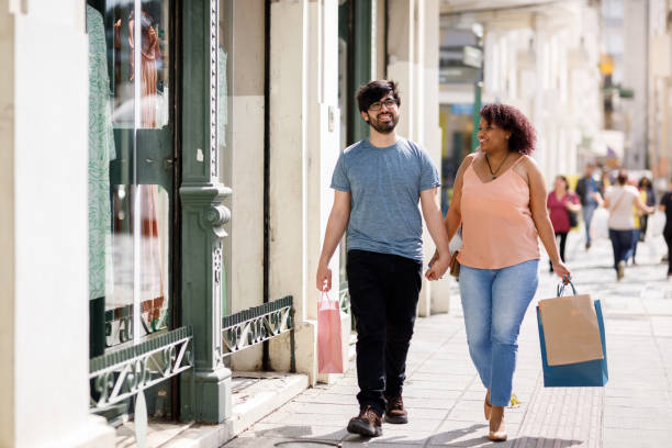 istock Happy couple walking while holding shopping bags 1434509233
