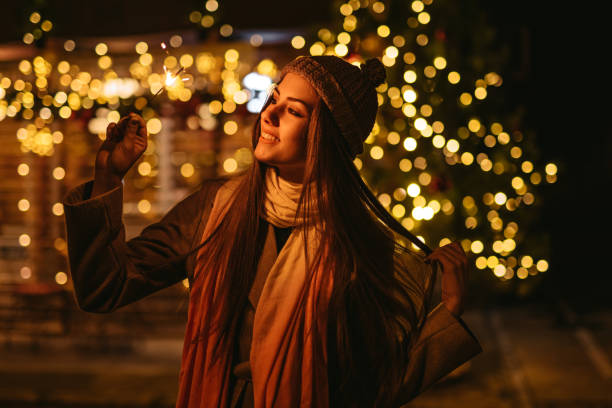 istock Young Woman Holding Sparkles Outdoors At Christmas 1434509718
