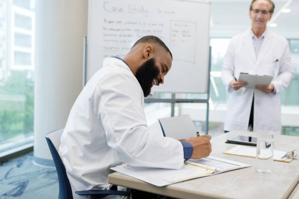 istock Male head doctor smiles while signing paperwork 1434511344