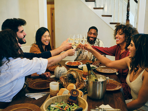 A group of friends celebrating Thanksgiving dinner together in a home.