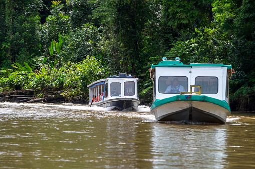 Limon, Costa Rica - September 11, 2022: River boats with passengers navigating at the Tortuguero canal