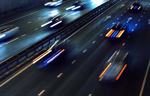Car traffic lights on the highway road at dark night, above view, motion blur