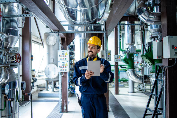 worker supervisor in district heating plant doing quality control and inspection of pipes and valves. - boiler power station gas boiler industrial boiler imagens e fotografias de stock