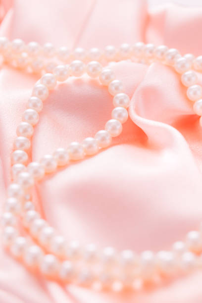 istock Pearl necklace on pink satin fabric. Wedding concept. Soft focus 1434517798
