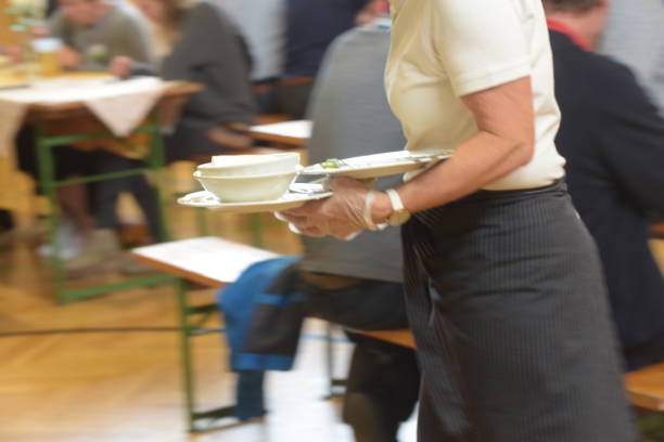 waitress serving food to costumers waitress in a restaurant is serving food to the costumers minimum wage stock pictures, royalty-free photos & images